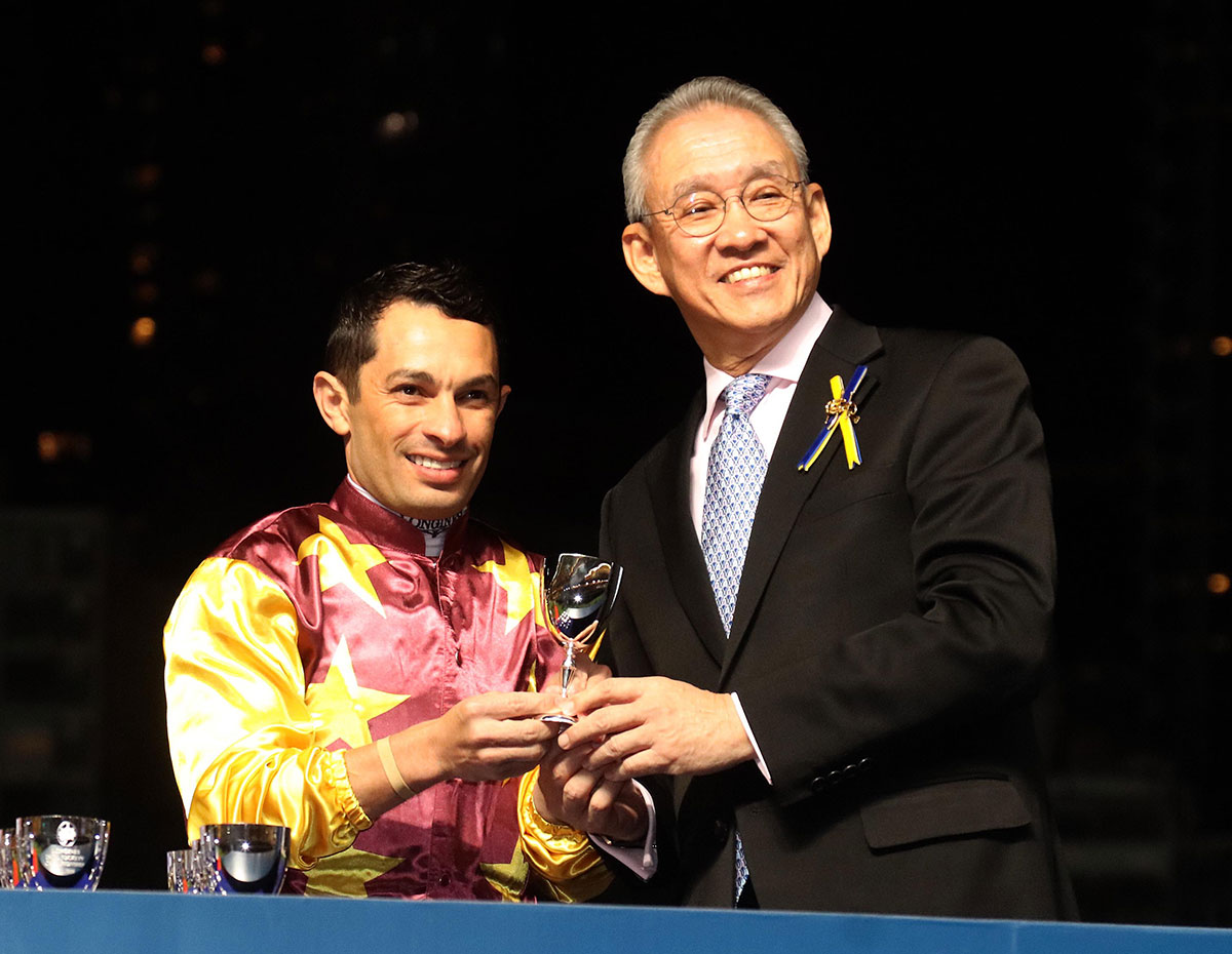 Dr Anthony W K Chow, Chairman of the Club, presents a silver goblet to each of the 12 participating jockeys.