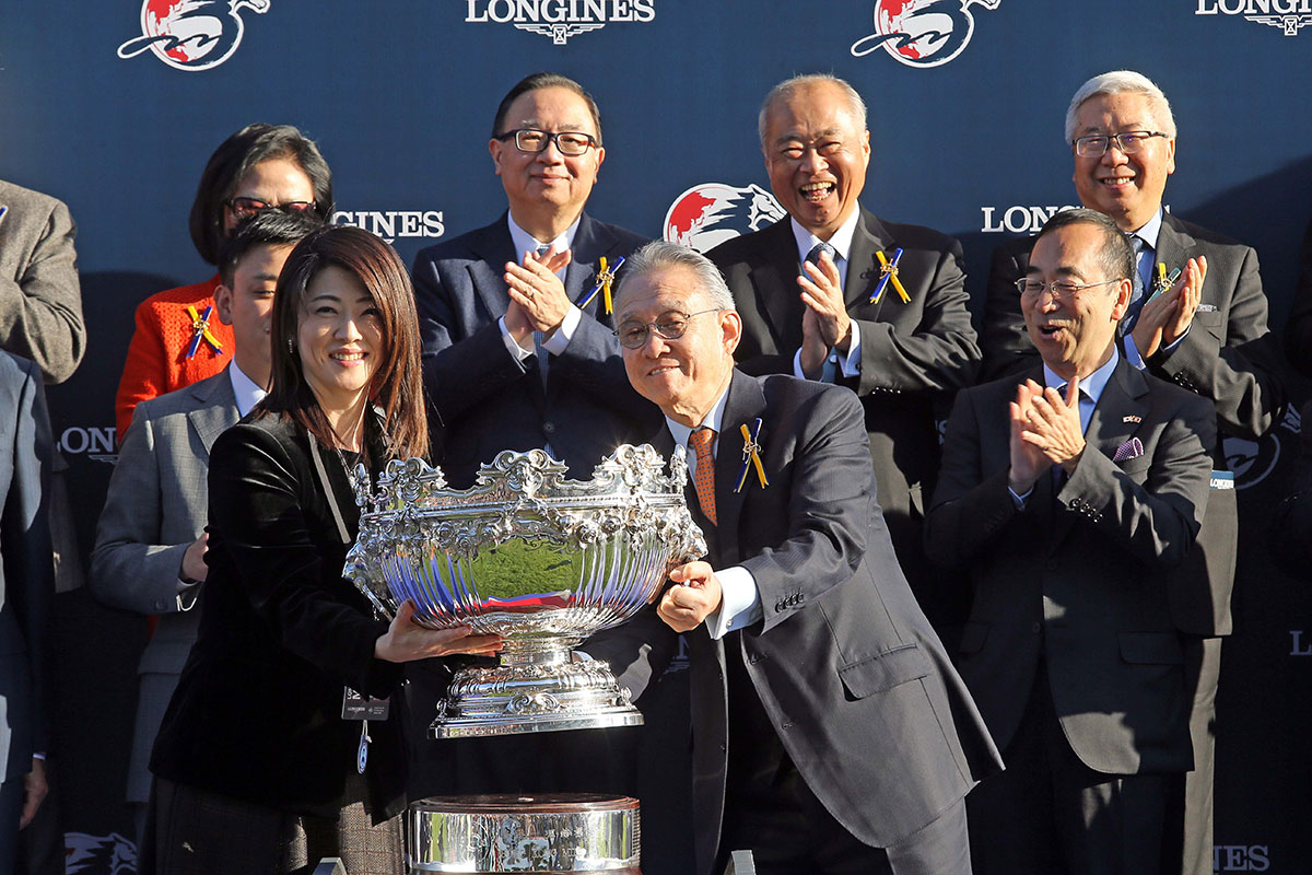 Dr Anthony Chow(right), Chairman of HKJC presents the LONGINES Hong Kong Mile trophy to owner representative of Admire Mars.