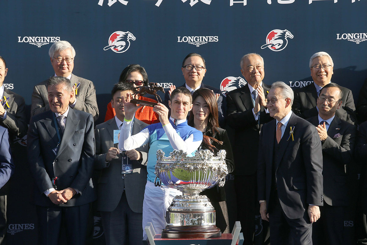 Dr Anthony Chow(right), Chairman of HKJC presents a bronze horse and jockey statuette to owner representative of Admire Mars, trainer Yasuo Tomomichi and jockey Christophe Soumillon.