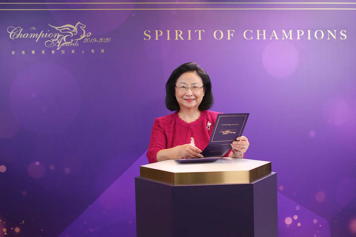 Mrs. Margaret Leung, Steward of The Hong Kong Jockey Club, announces the Champion Miler award goes to Beauty Generation, owned by Mr. Patrick Kwok Ho Chuen. Mr. Patrick Kwok Ho Chuen accompanied by his father Dr. Simon Kwok Siu Ming pose with the winning trophy.