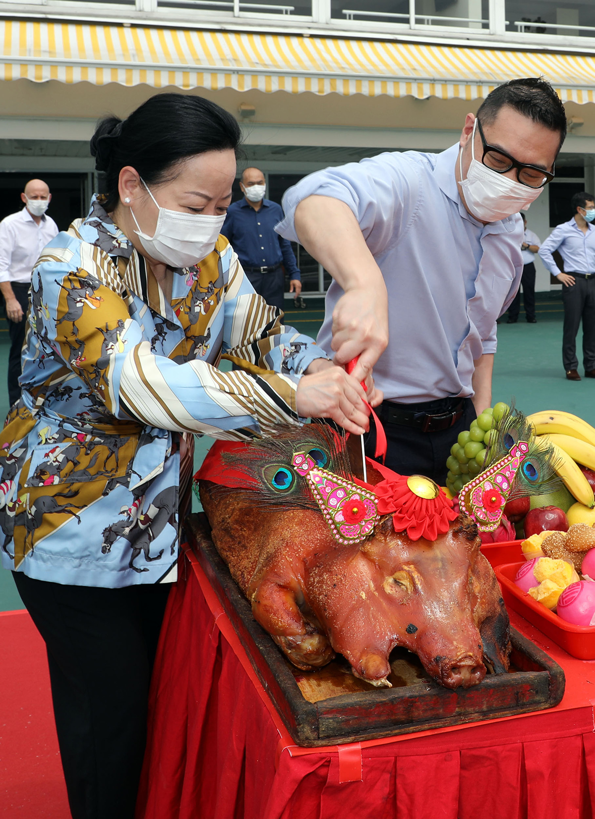 Senior Club officials carve the roasted pigs at the bai sun ceremony.