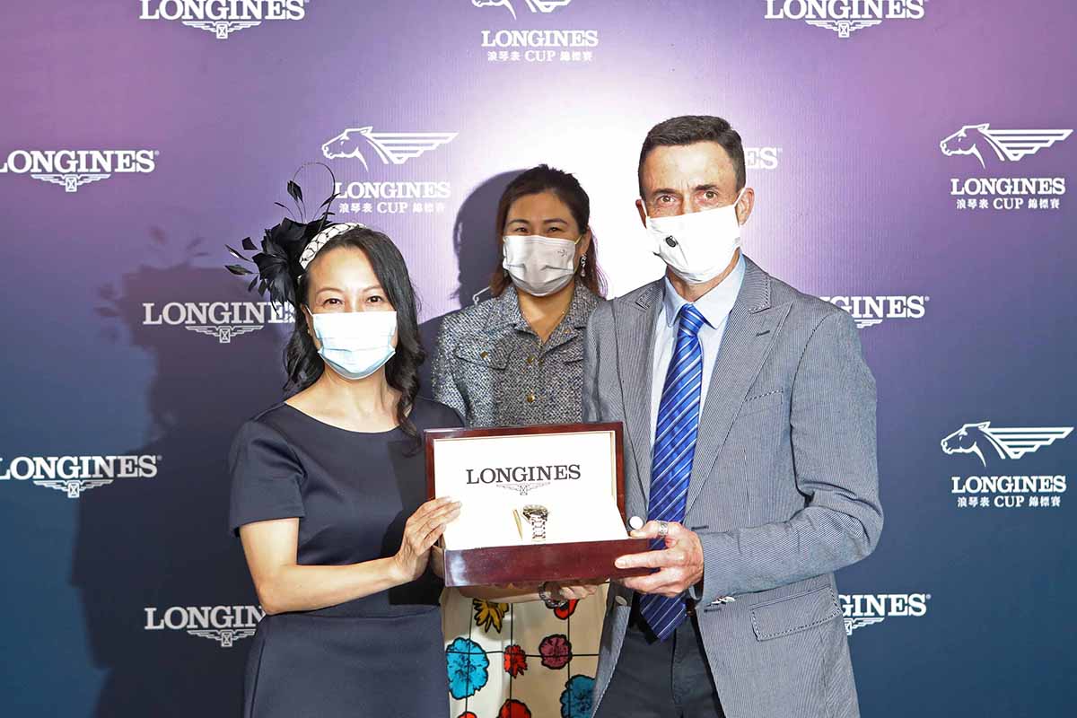 Ms. Nancy Tse, Vice President of LONGINES Hong Kong, presents a LONGINES Master Collection watch to the owner representative of Beauty And The Best Syndicate, trainer Douglas Whyte and jockey Keith Yeung, winning connections of Best Alliance.