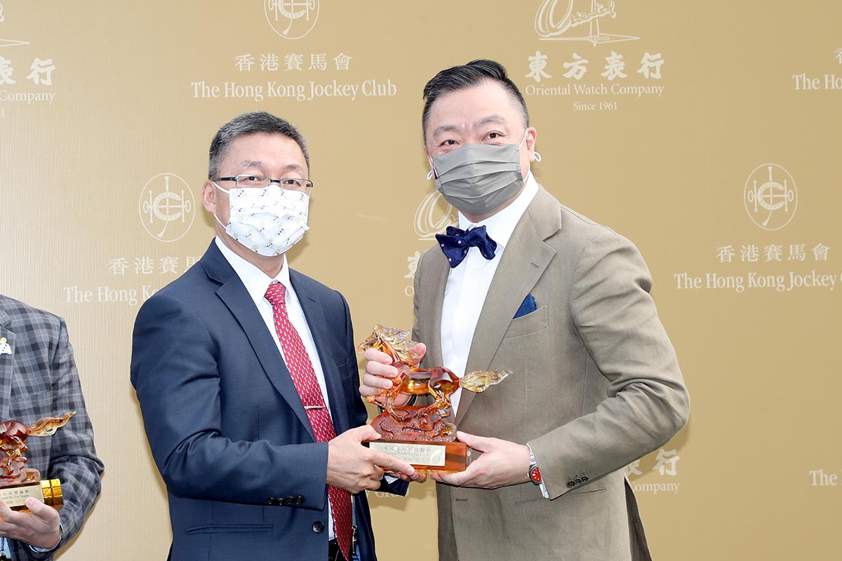 Dennis Yeung Him Kit, Managing Director of the Oriental Watch Company Limited presents a souvenir to Golden Sixty’s owner Stanley Chan Ka Leung, trainer Francis Lui and jockey Vincent Ho.