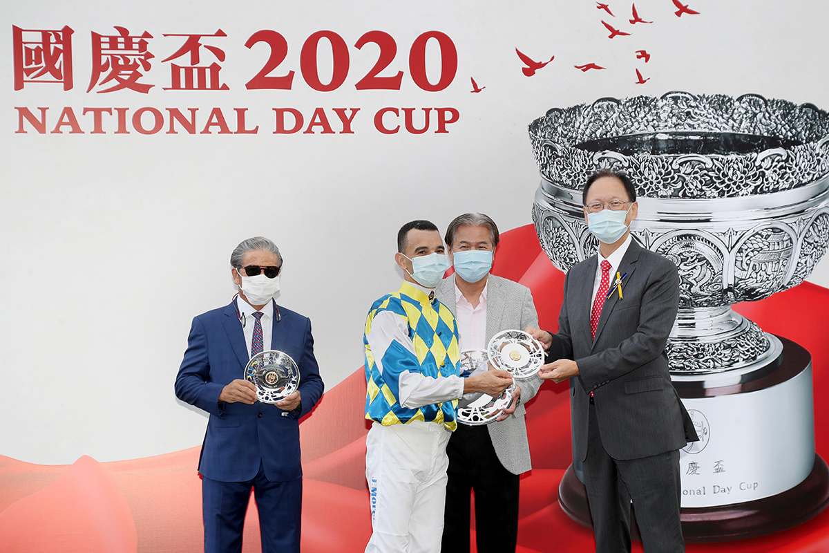 Philip Chen, Chairman of The Hong Kong Jockey Club, presents the National Day Cup and silver dishes to Computer Patch’s owner Yeung Kin Man, trainer Tony Cruz and jockey Joao Moreira.