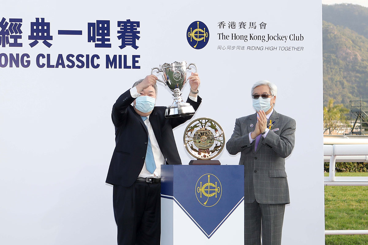 HKJC Steward Dr Eric Li Ka Cheung (right) presents the winning trophy and gold-plated dish to Owner Kenneth Chung Kin Shu.
