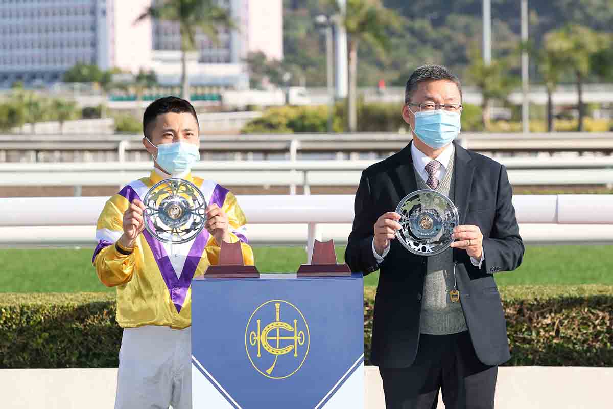 Winning trainer Francis Lui and winning jockey Matthew Poon pose for a photo with silver dishes.