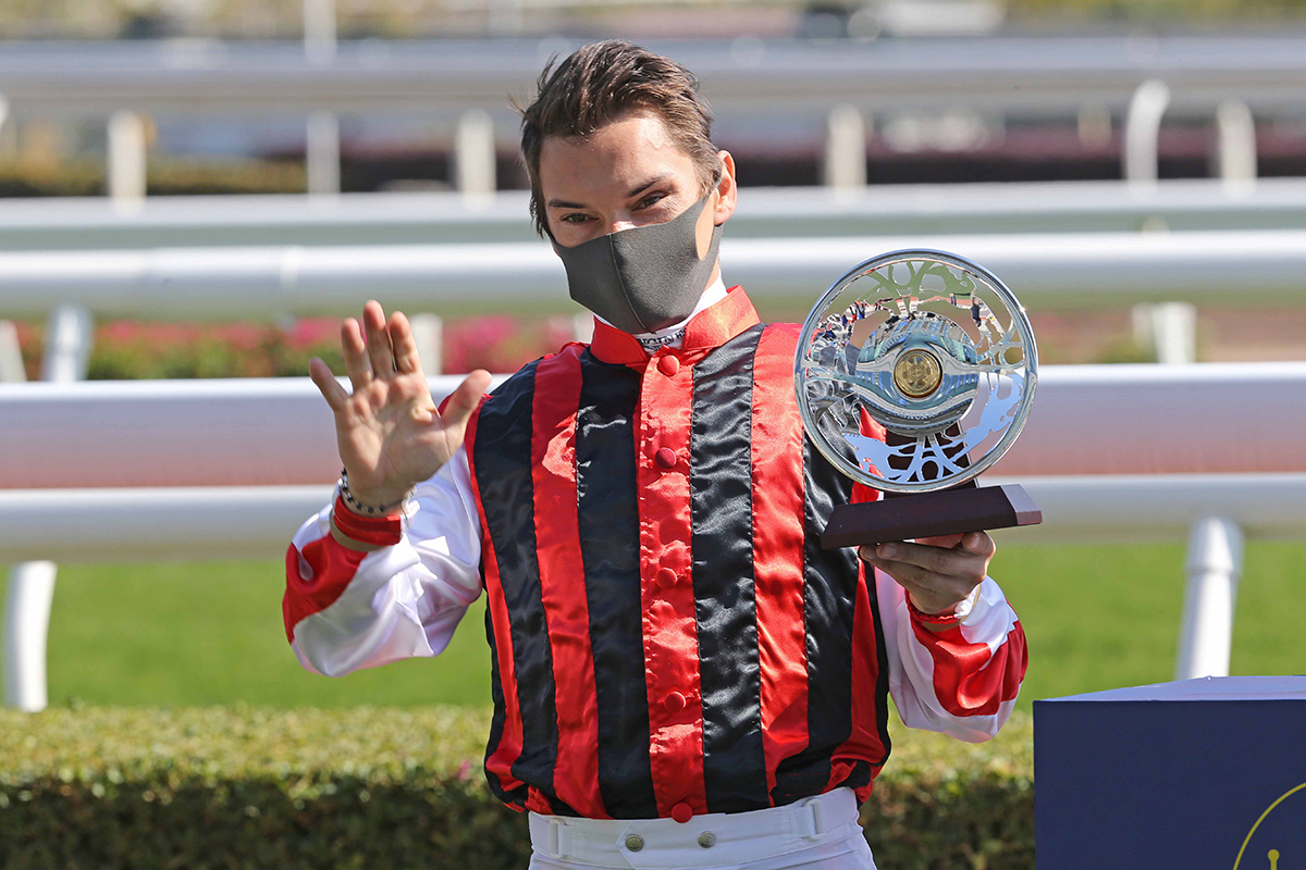 Winning jockey Alexis Badel poses for a photo with a silver dish.