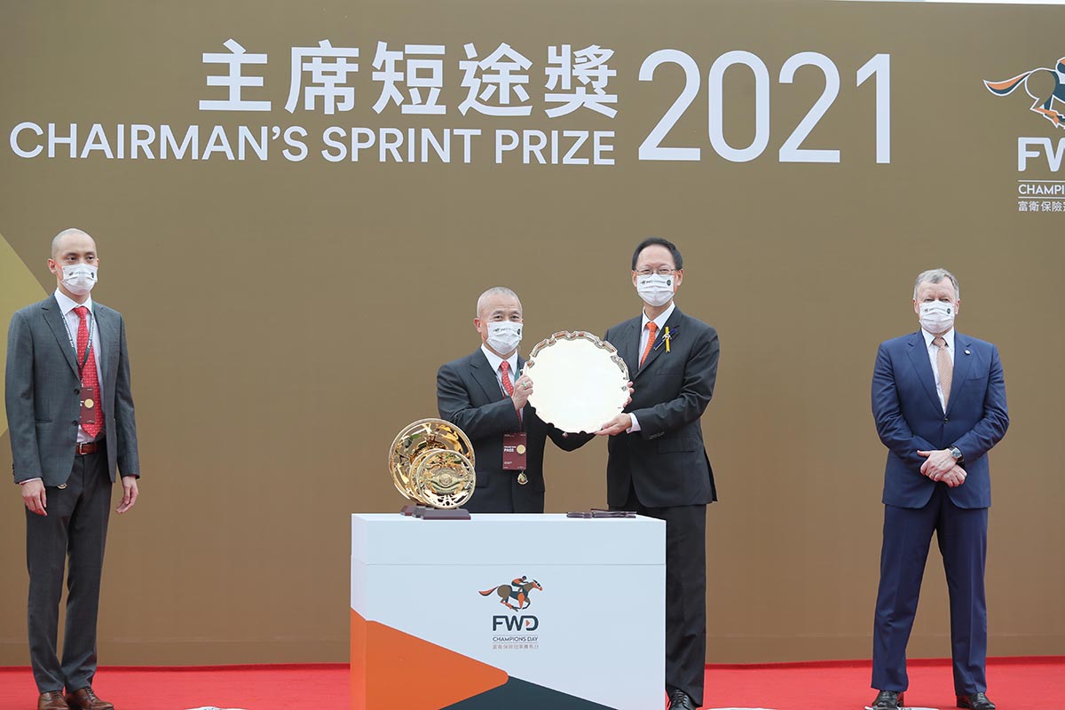 HKJC Chairman Philip Chen presents the Chairman’s Sprint Prize Trophy and gold-plated dishes to Wellington’s Owners Michael Cheng Wing On and Jeffrey Cheng Man Cheong, trainer Richard Gibson and jockey Alexis Badel.