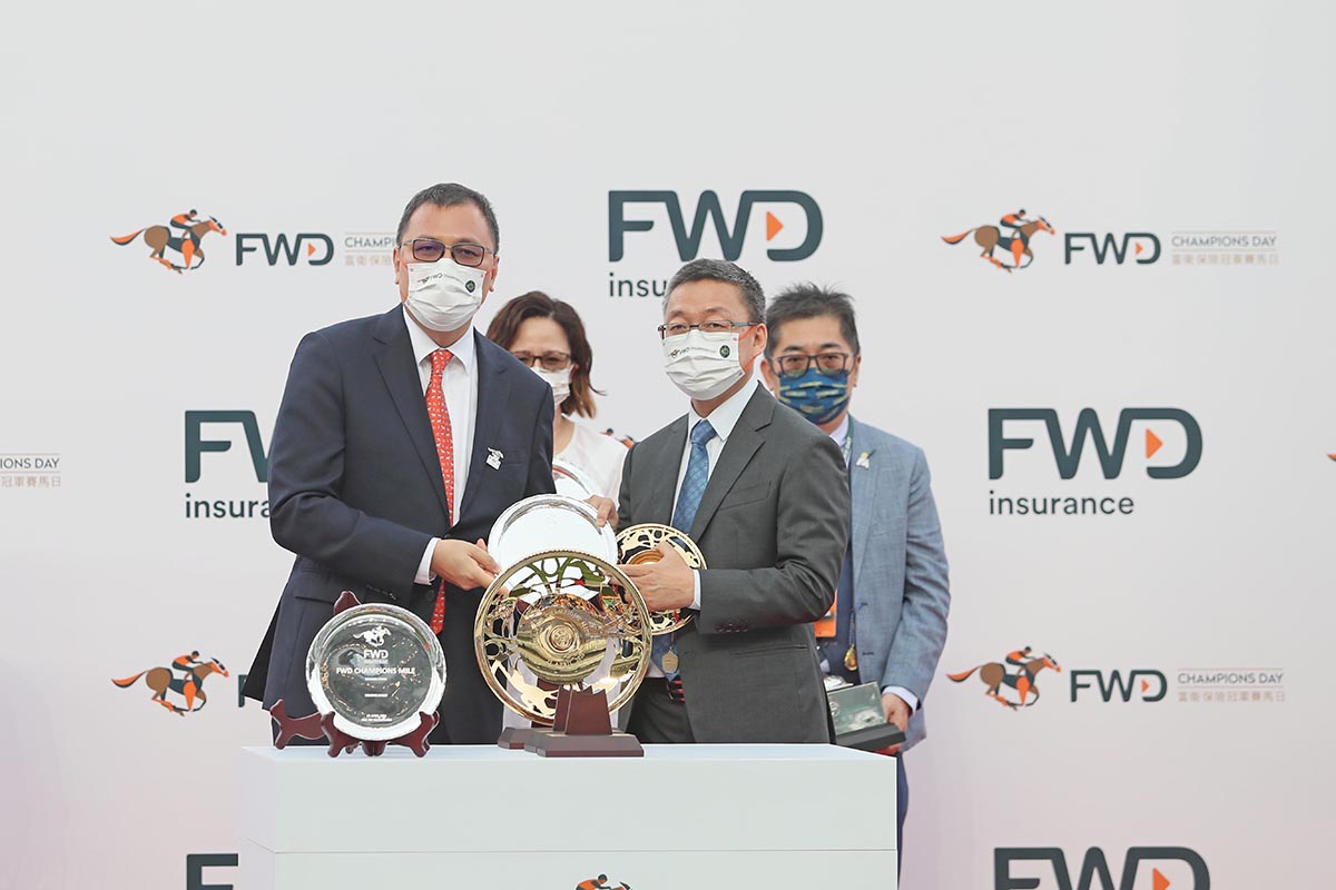 Mr Ken Lau, Managing Director of FWD Greater China and Hong Kong Chief Executive Officer, present a souvenir to winning trainer Francis Lui.
