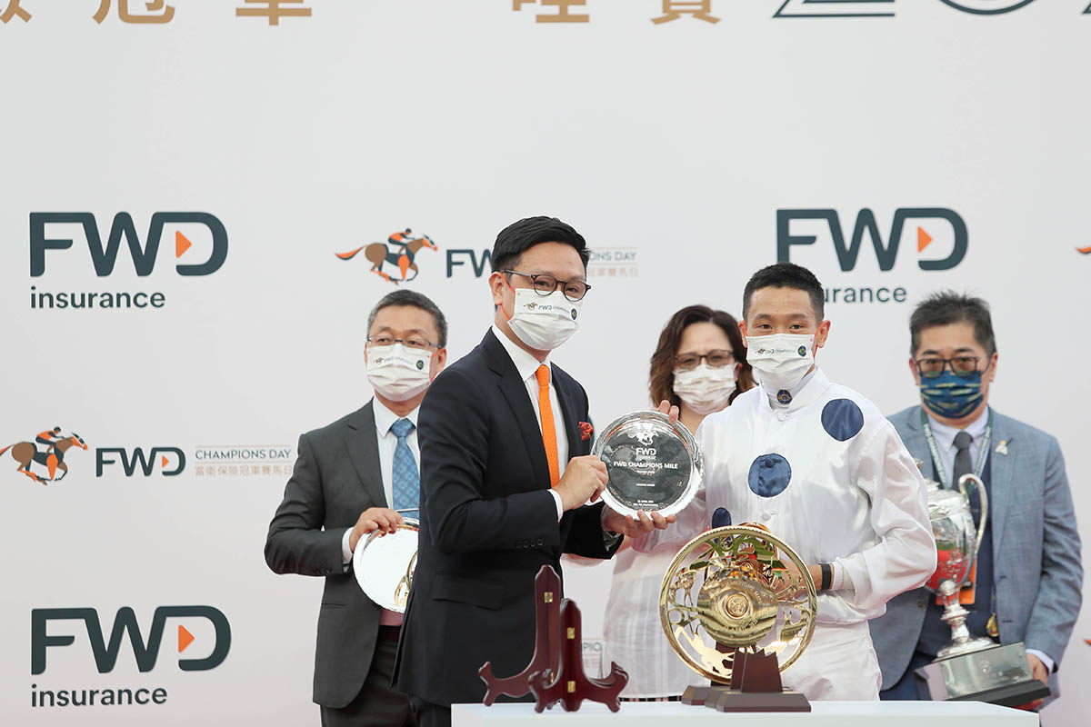 Mr Paul Tse, Chief Marketing Officer of FWD Greater China, present a souvenir to winning jockey Vincent Ho.