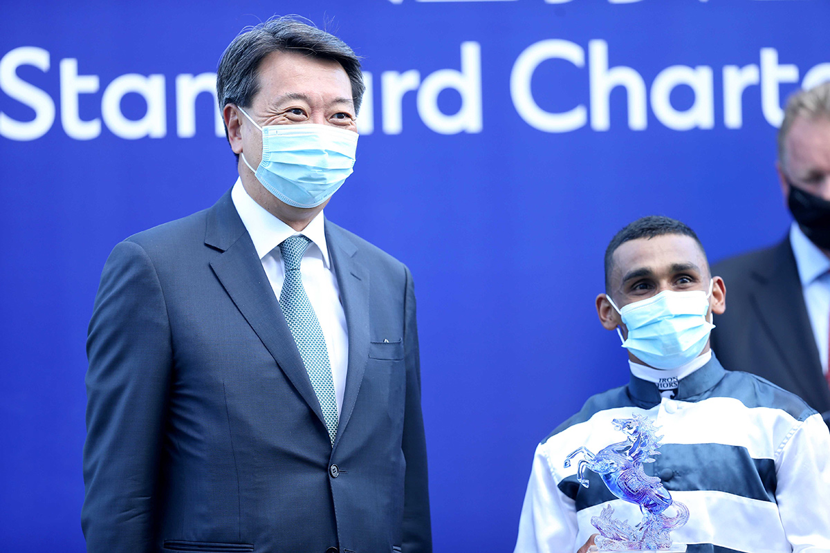Benjamin Hung (left), Chief Executive Officer, Asia, Standard Chartered Bank, presents souvenirs to Panfield’s Owner representative and jockey Karis Teetan.