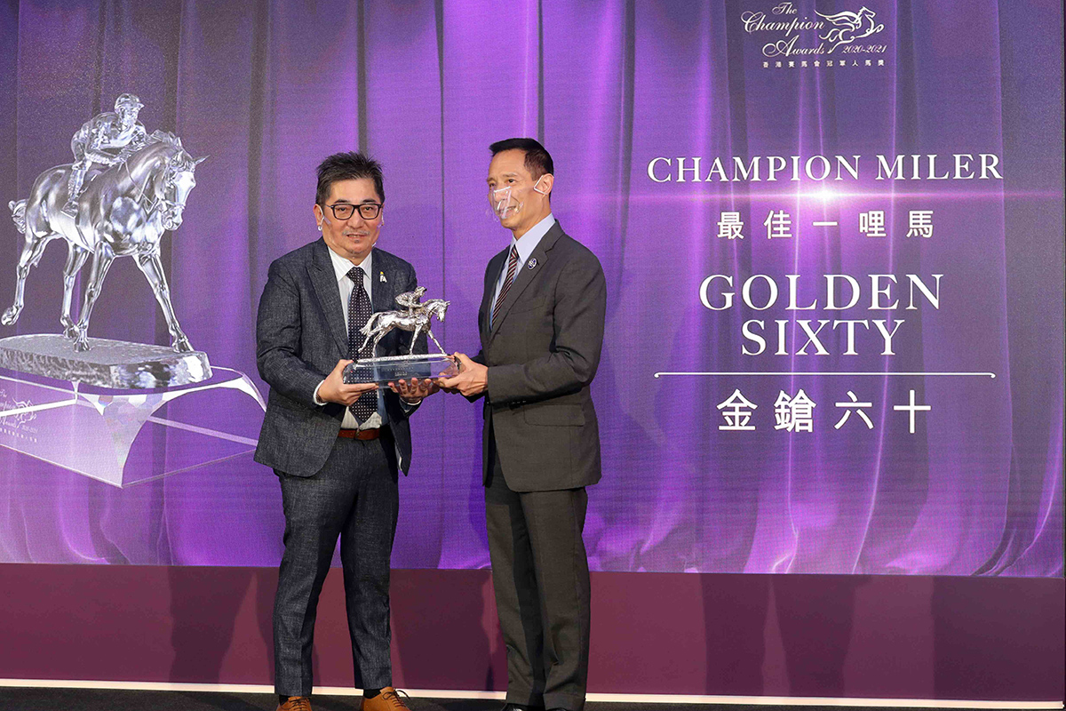 Mr. Richard Tang, Steward of The Hong Kong Jockey Club, presents the Champion Miler trophy to Mr. Stanley Chan Ka Leung, owner of Golden Sixty.
