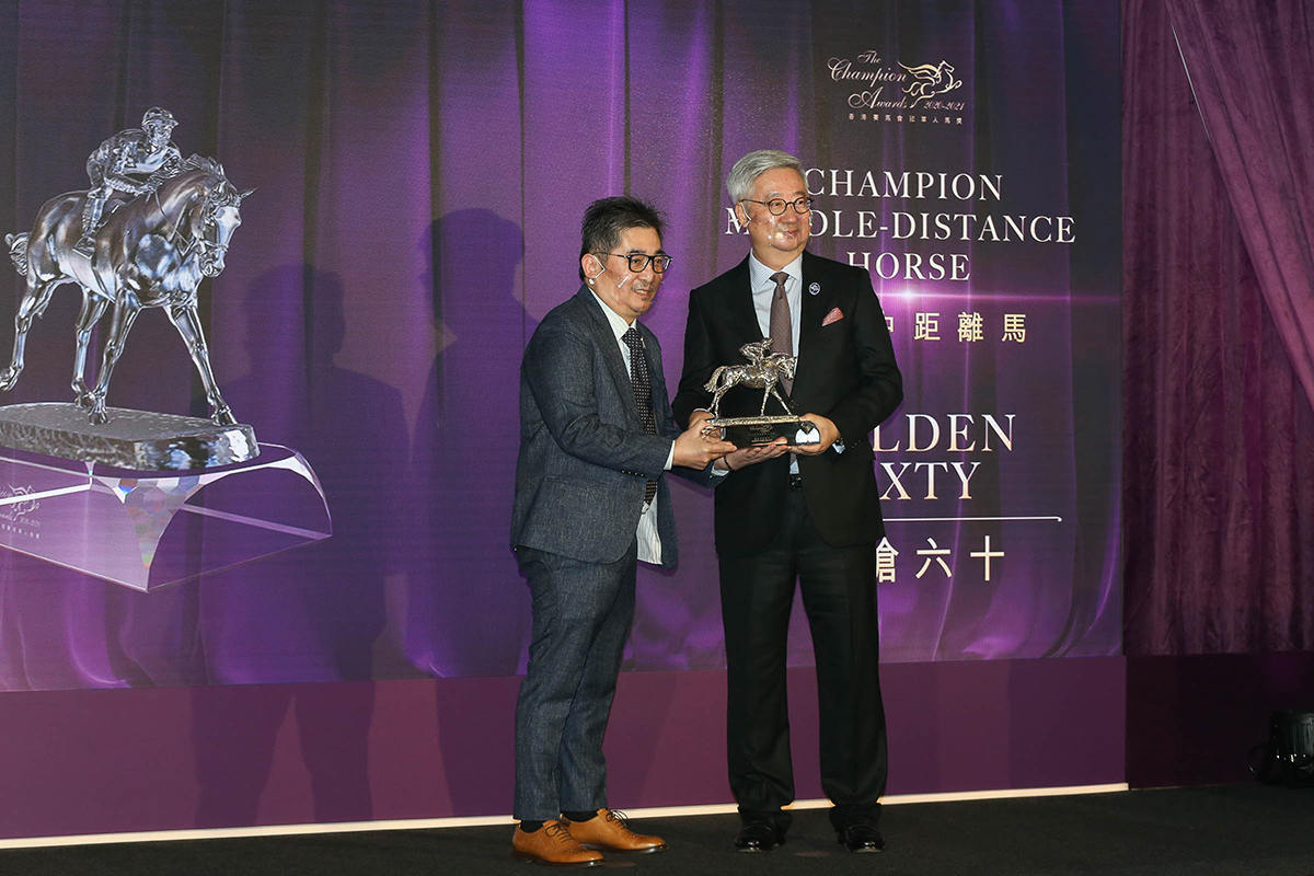 Dr. Silas Yang, Steward of The Hong Kong Jockey Club, presents the Champion Middle-Distance trophy to Mr. Stanley Chan Ka Leung, owner of Golden Sixty.