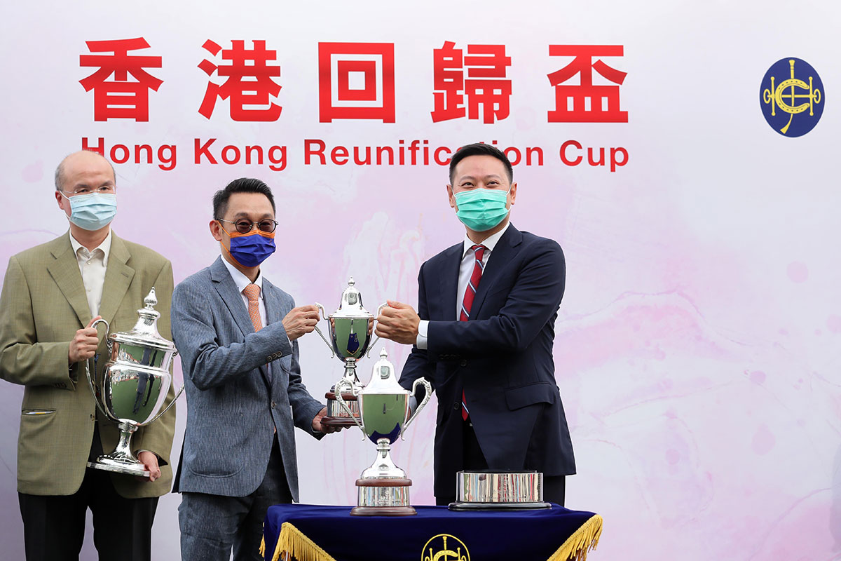 At The Hong Kong Reunification Cup trophy presentation, The Honourable Caspar Tsui Ying-wai JP (right), Secretary for Home Affairs of the HKSAR Government, presents The Hong Kong Reunification Cup and commemorative trophies to Super Football’s Owner Robert Lau and trainer Jimmy Ting.
