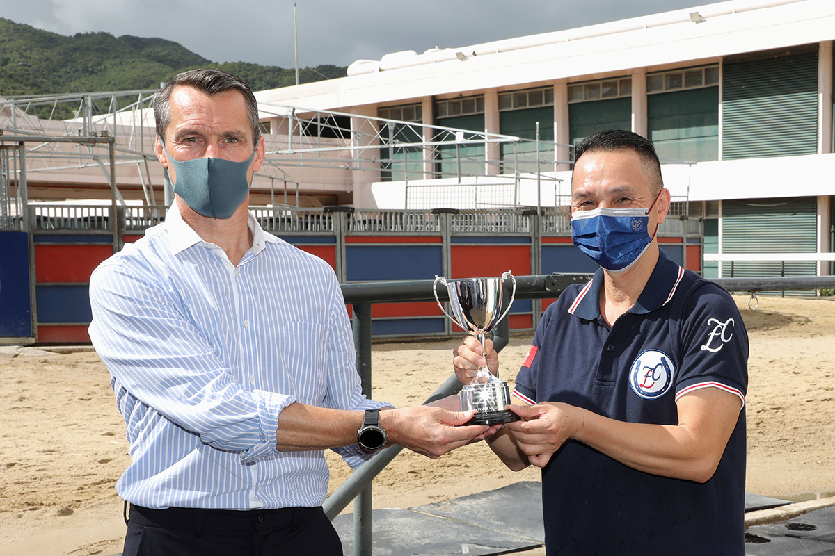Mr. Stephen Higgins (left), the Club’s Head of Raceday Operations, Tracks and Racing Facilities and Chairman of the Safety Committee (Racing Operations and Racing Development Board), presents the stable prize to the representative of the stable staff of Frankie Lor.