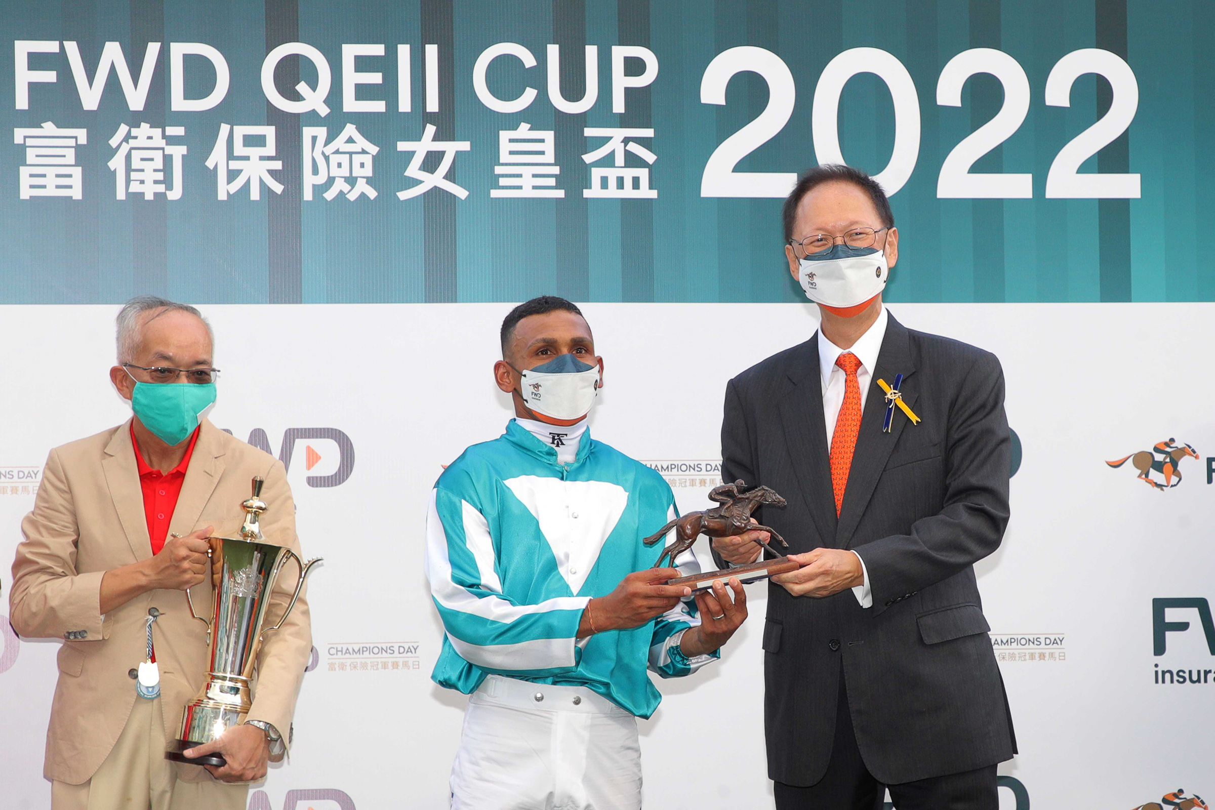 HKJC Chairman Philip Chen presents the trophy and bronze statuettes of a horse and jockey to Romantic Warrior’s owner Peter Lau Pak Fai and owner’s representative, trainer Danny Shum and jockey Karis Teetan.