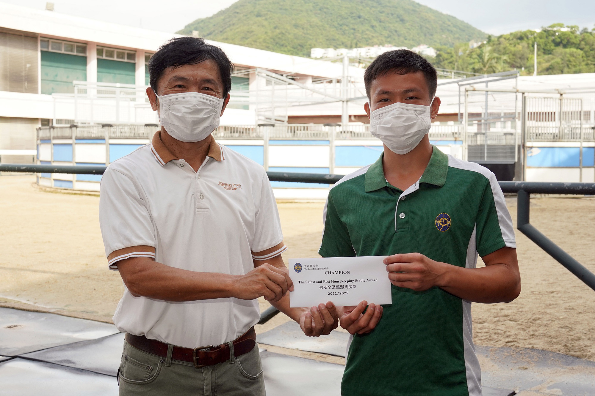 Samson Lau (left), Training Manager/Safety Manager, Racing Talent Training Centre, presents the stable prize to Wong Pui Kan (right), Work Rider of the Caspar Fownes stable.
