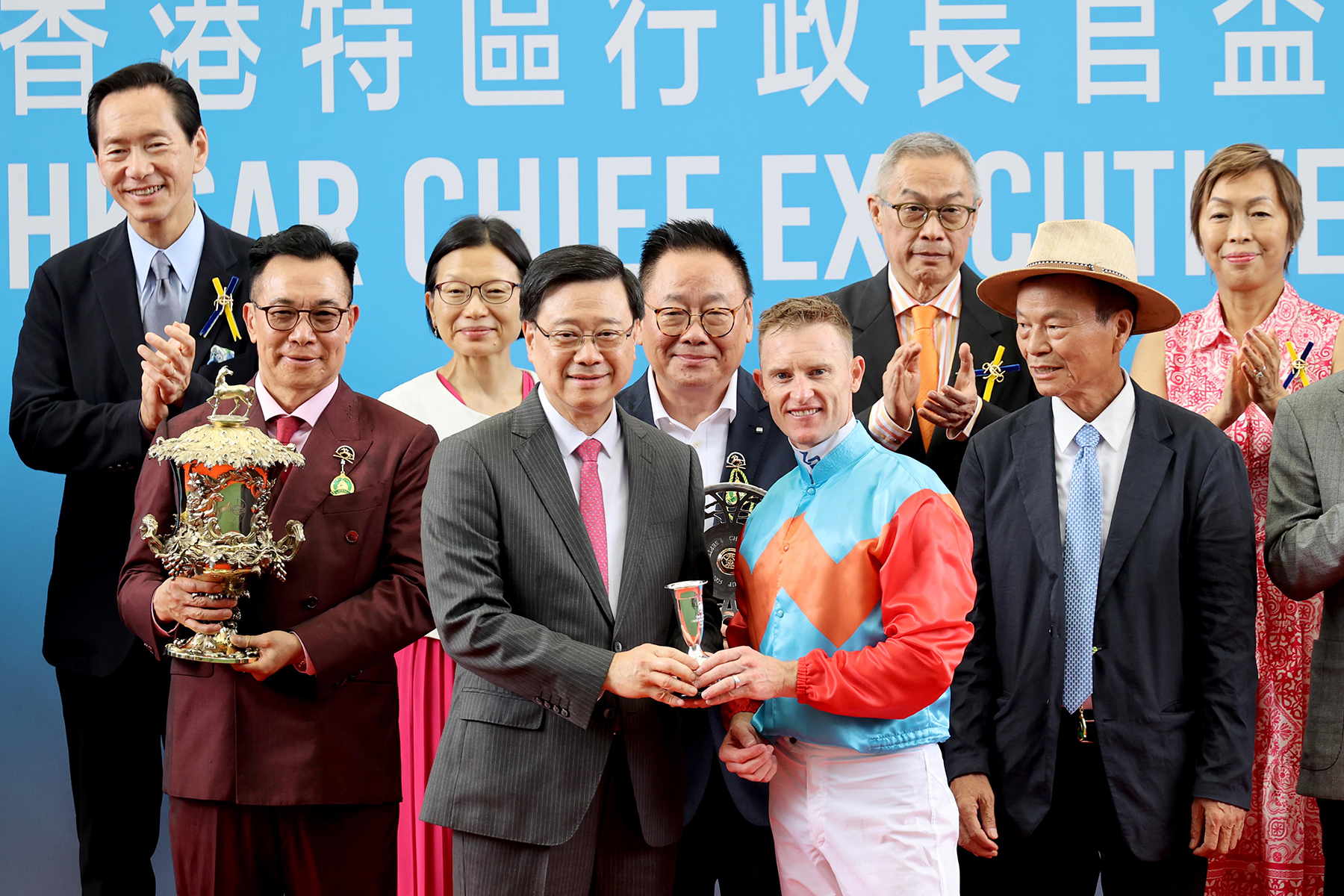 The Honourable John KC LEE, GBM, SBS, PDSM, PMSM, The Chief Executive of the Hong Kong Special Administrative Region, presents the cup and silver dish to Ka Ying Rising’s owner representatives of the Ka Ying Syndicate, as well as a souvenir to trainer David Hayes and jockey Zac Purton, during the trophy presentation ceremony.
